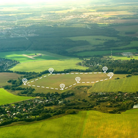 Landschaftsaufnahme. Auf einem freien Feld ist eine Fläche digital abgesteckt. 