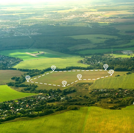 Landschaftsaufnahme. Auf einem freien Feld ist eine Fläche digital abgesteckt. 