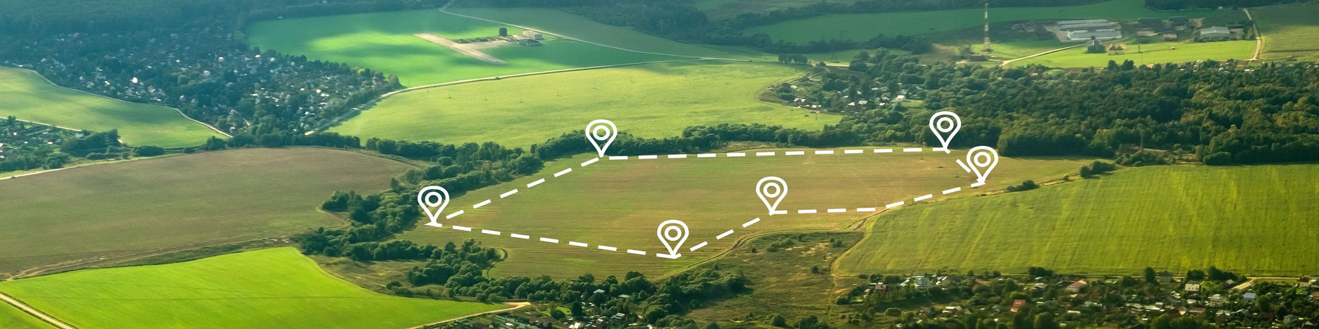 Landschaftsaufnahme. Auf einem freien Feld ist eine Fläche digital abgesteckt. 