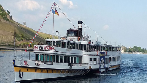 ein Freizeitschiff mit Wimpeln auf einem Fluss