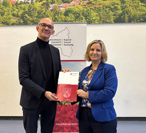 Klimaschutzministerin Katrin Eder überreicht den Förderbescheid an Marc Ullrich, Bürgermeister der Verbandsgemeinde Bad Kreuznach.